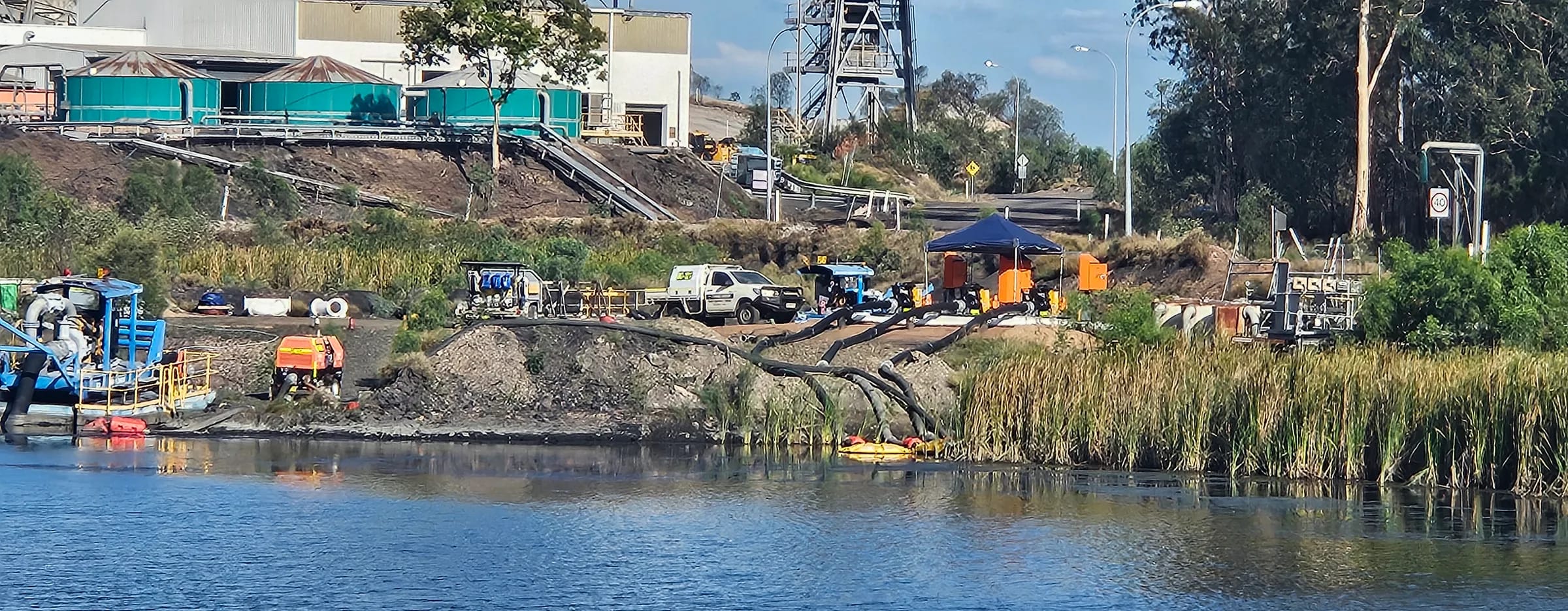 Pump station and pipework on the water of the Stockpile Dam at Clermont Coal Mine, with the plant behind